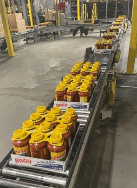 Photo of jars of Ragu pasta sauce in boxes on an assembly line in a manufacturing plant